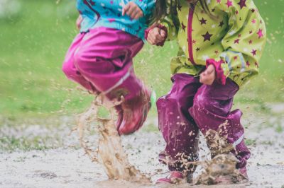 Twee kinderen stampen in een waterplas